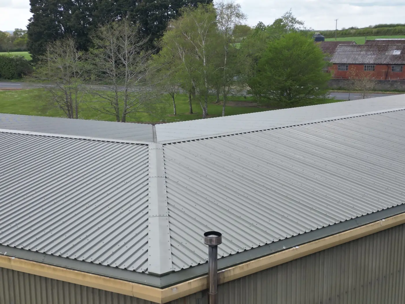 New roof sheets meeting the eaves and existing gutter line