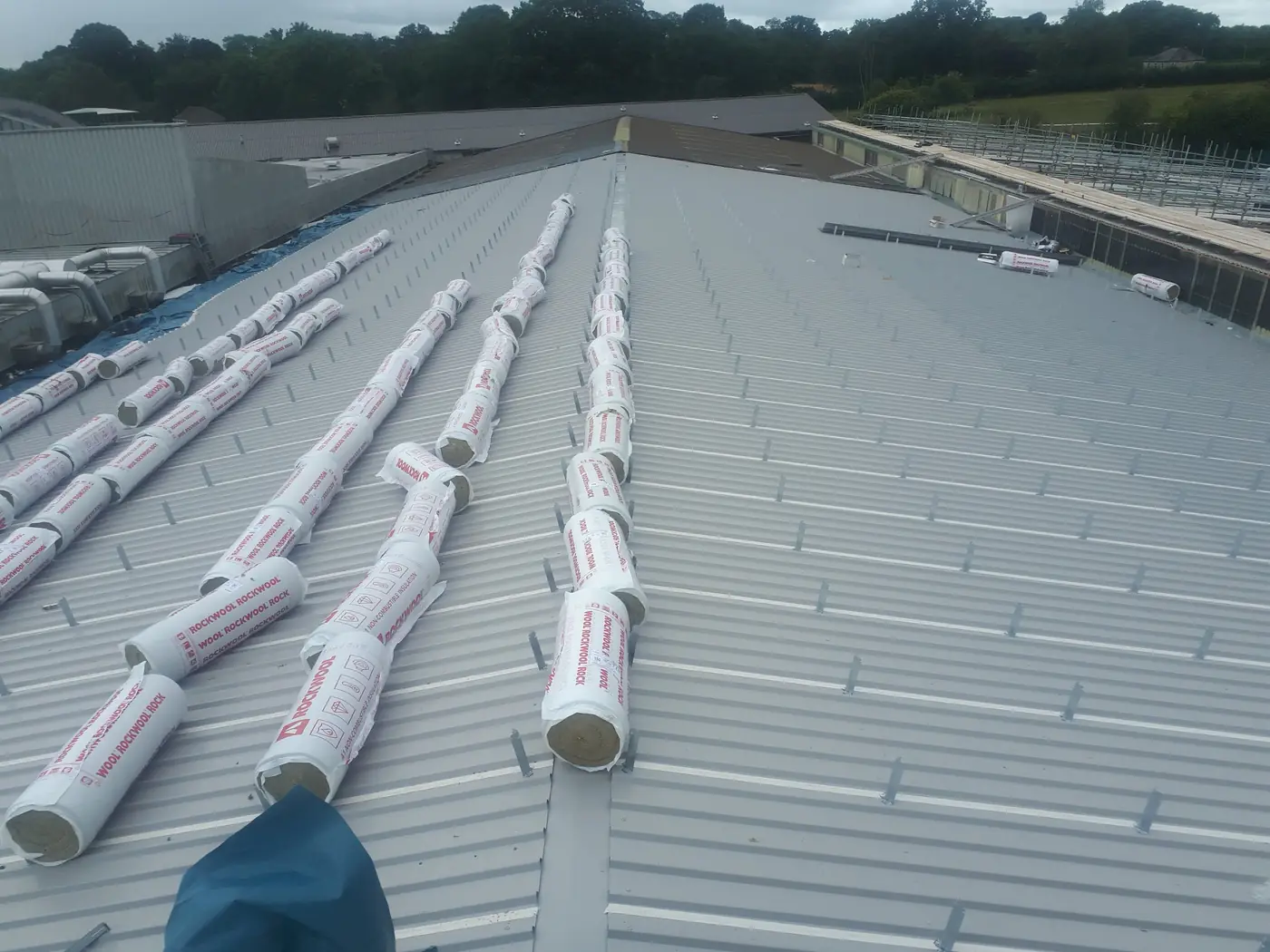 Insulation rolls laid out across the new roof liner