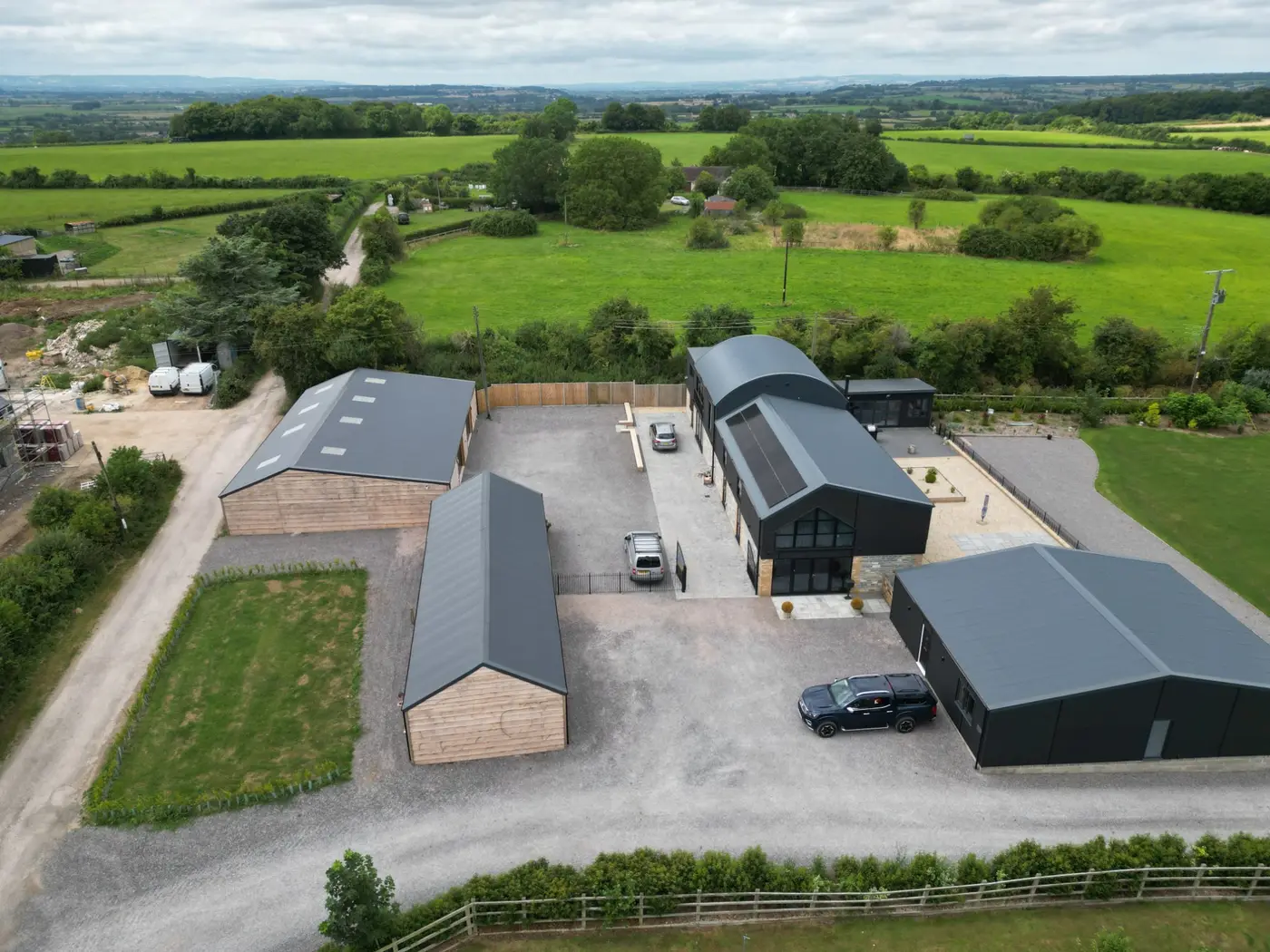 Bespoke residential buildings with metal roofs in a rural setting