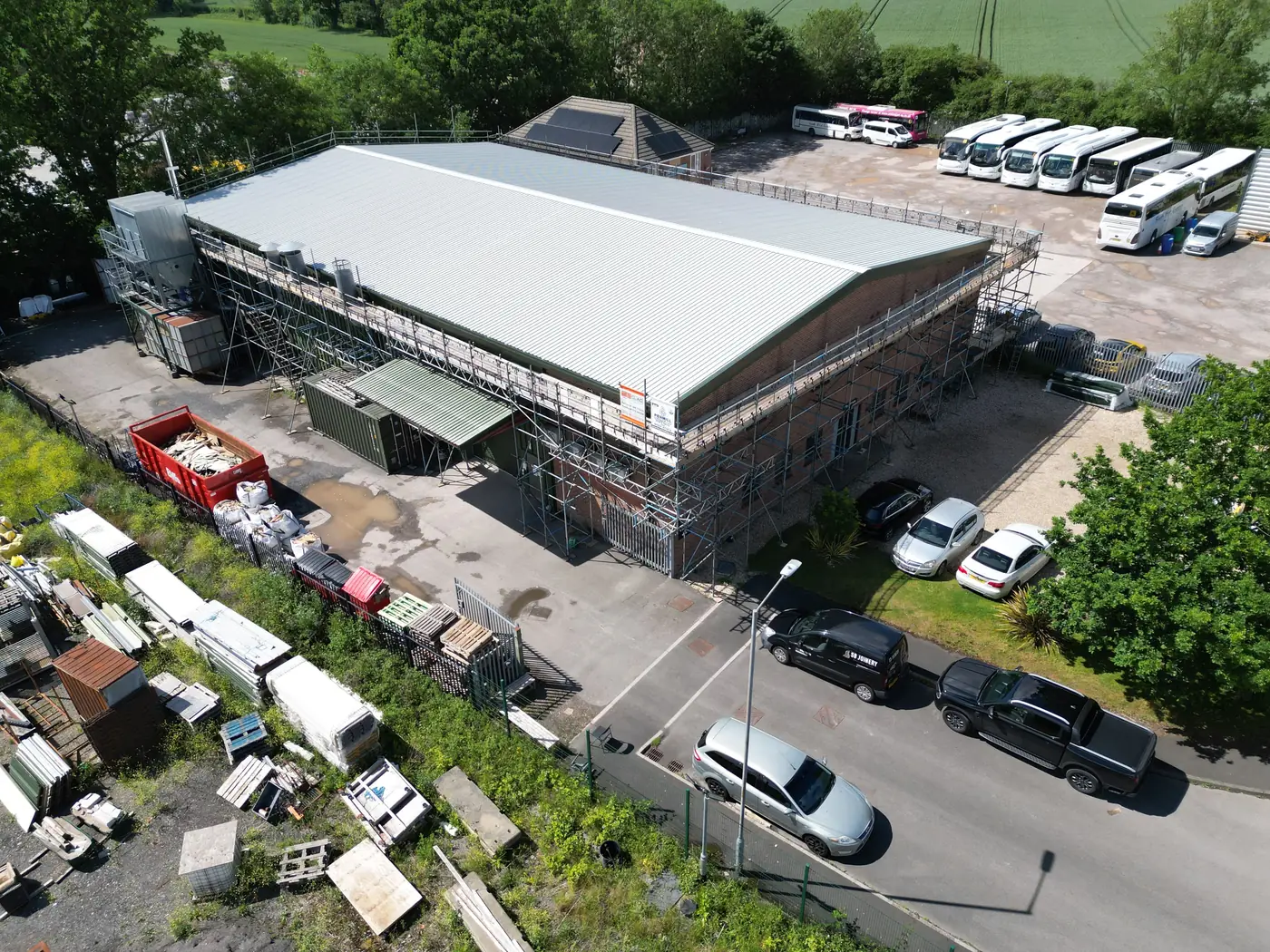 Scaffolding around the building with the yard and car park in use