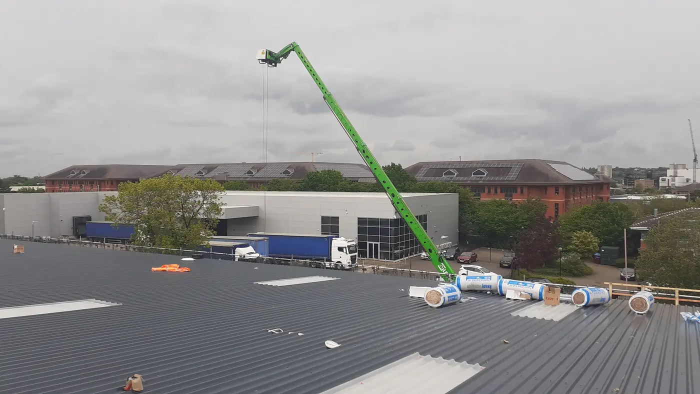Rotating telehandler lifting insulation onto the roof